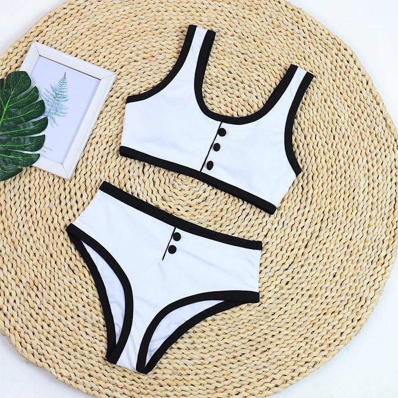 Maillot de bain deux pièces élégant pour femme, blanc avec bordures noires et boutons décoratifs.