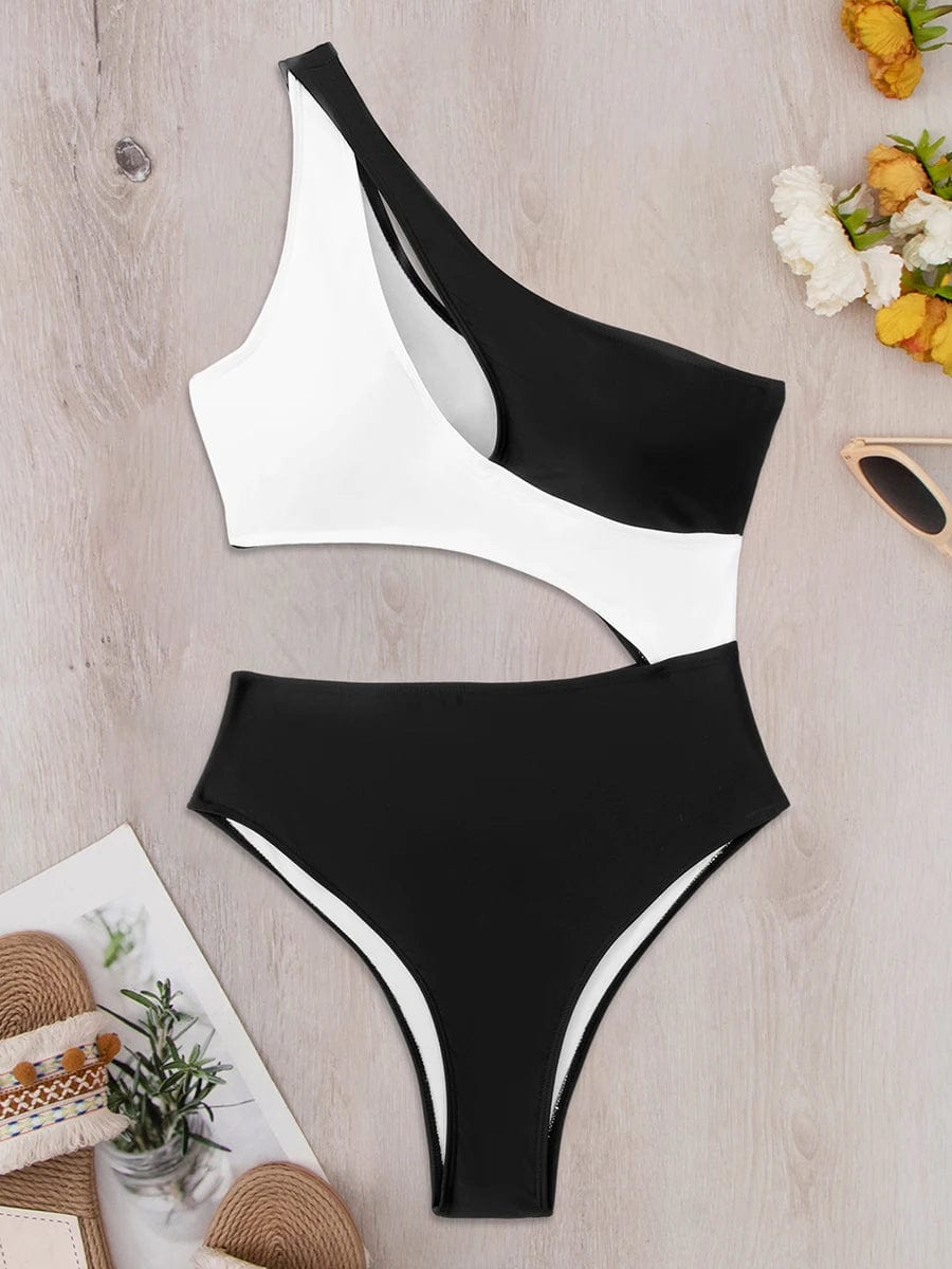 Maillot de bain une pièce noir et blanc, design asymétrique moderne sur fond en bois clair.