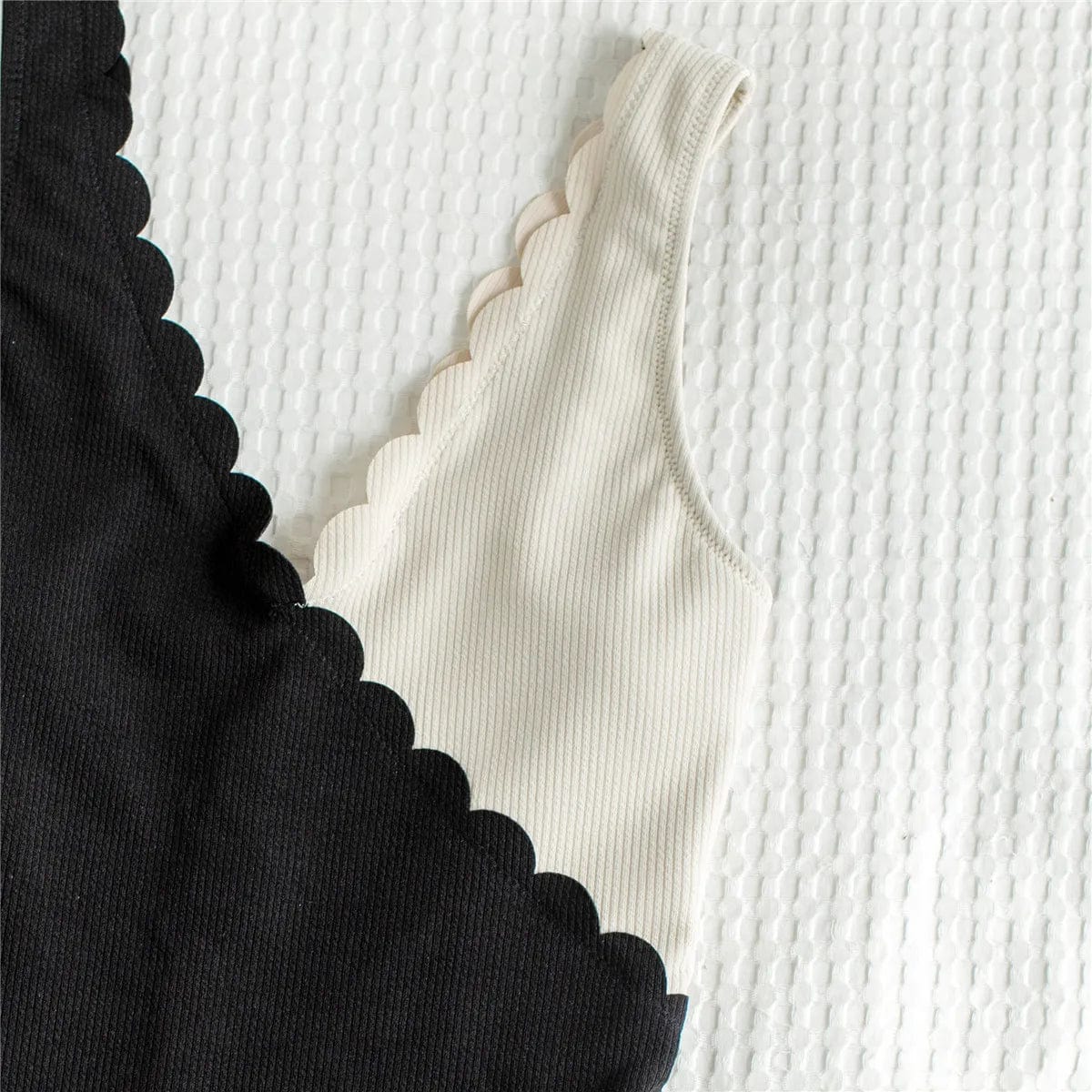 Maillot de bain une pièce asymétrique noir et blanc avec bords festonnés élégants et modernes.