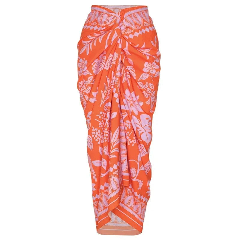 Maillot de bain femme avec paréo orange à motifs floraux pour un look estival élégant et coloré.