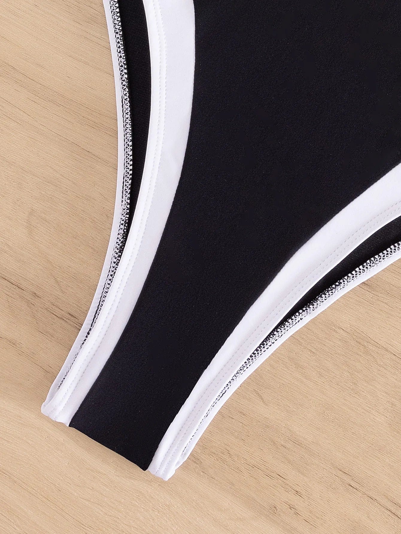 Maillot de bain pour femme, une pièce échancré, design chic avec bordures noires et blanches.