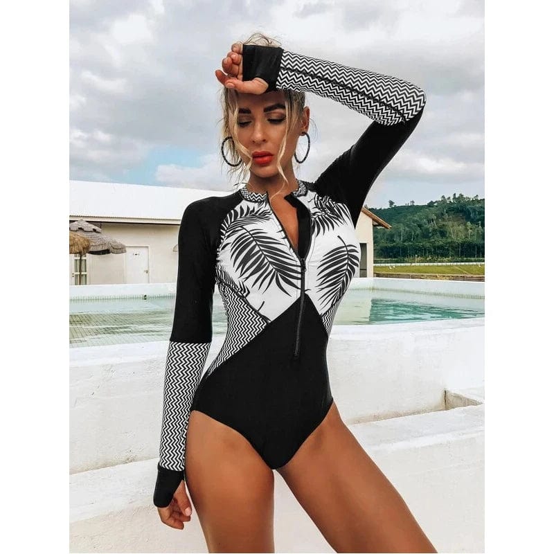 Maillot de bain une pièce femme noir et blanc, design tropical chic avec manches longues.