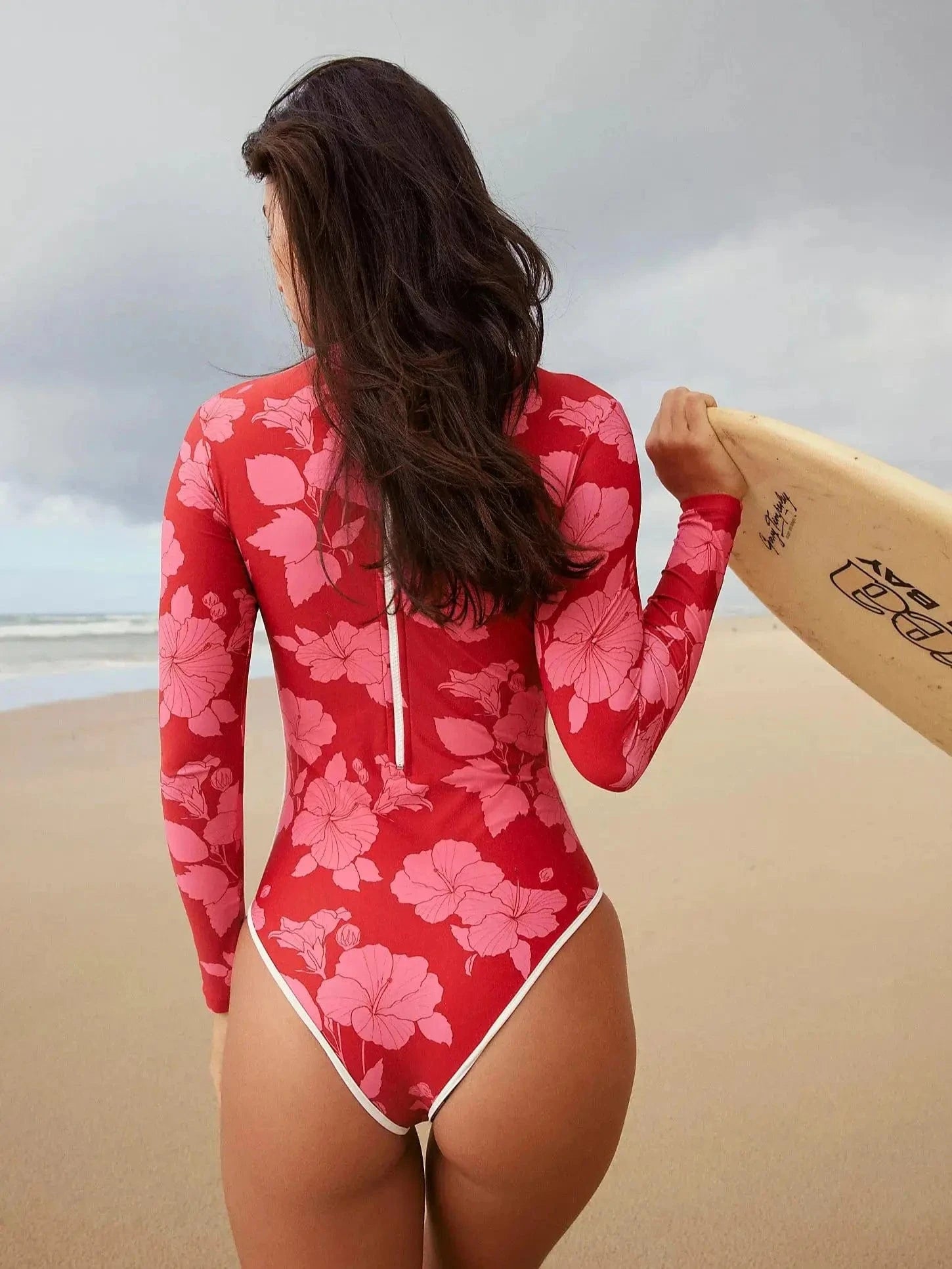 Maillot de bain une pièce fleuri rouge, manches longues, idéal pour surfer sur la plage.