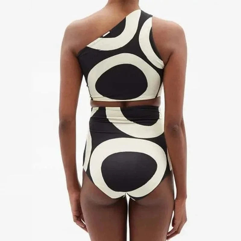 Maillot de bain une pièce pour femme avec motif graphique noir et blanc à épaules asymétriques.