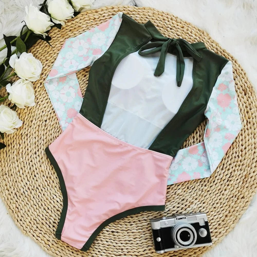 Maillot de bain une pièce femme avec manches longues à motifs floraux et couleurs pastel.