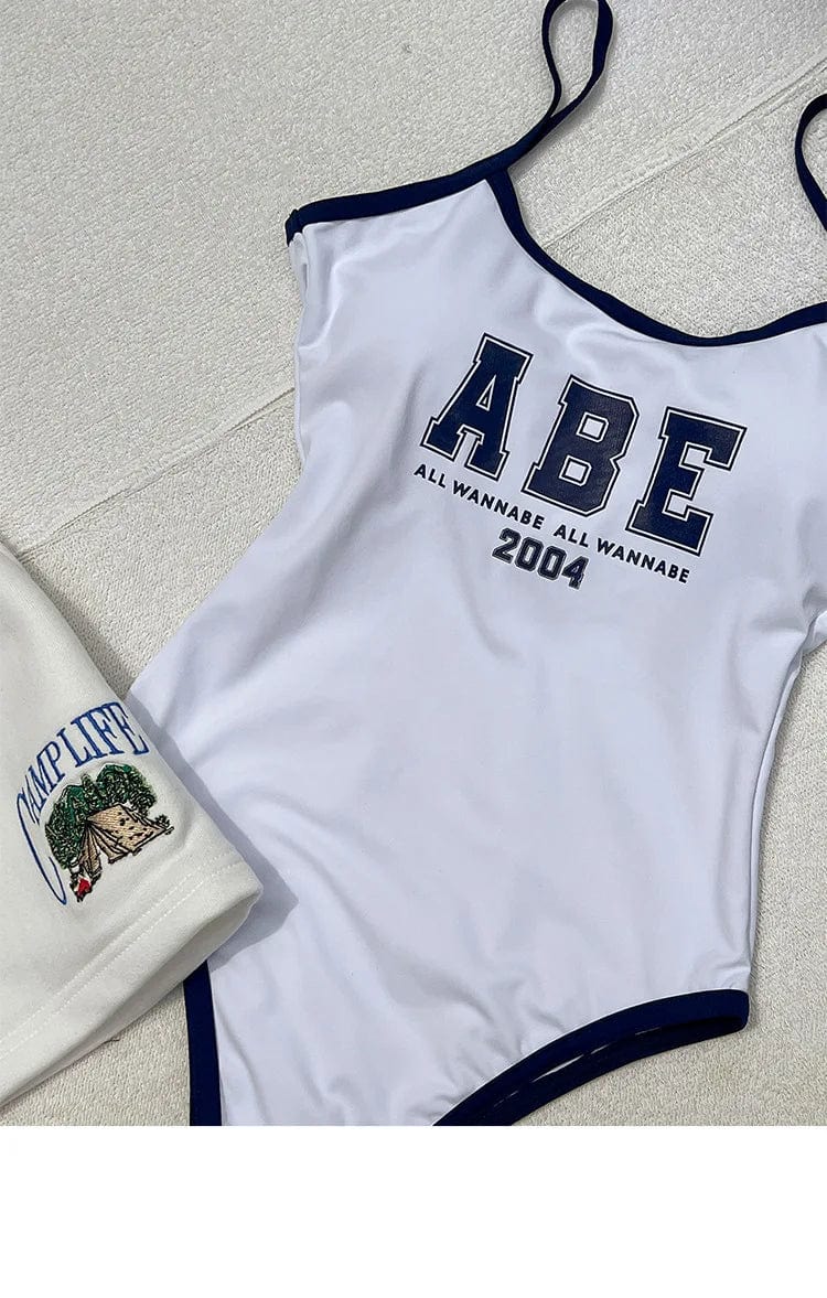 Maillot de bain une pièce blanc à bretelles avec imprimé texte, style décontracté et moderne.