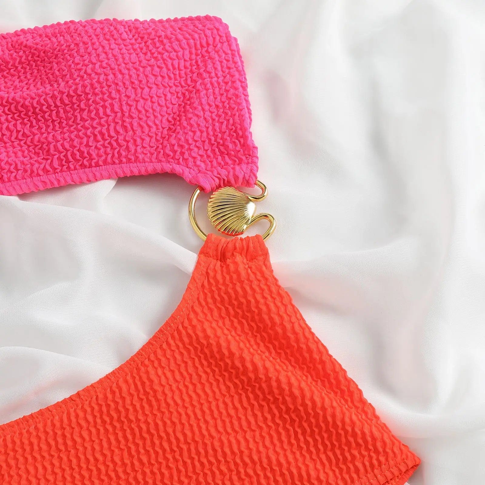 Maillot de bain femme asymétrique 2 pièces, détail tissu texturé rose et orange avec bijou doré.