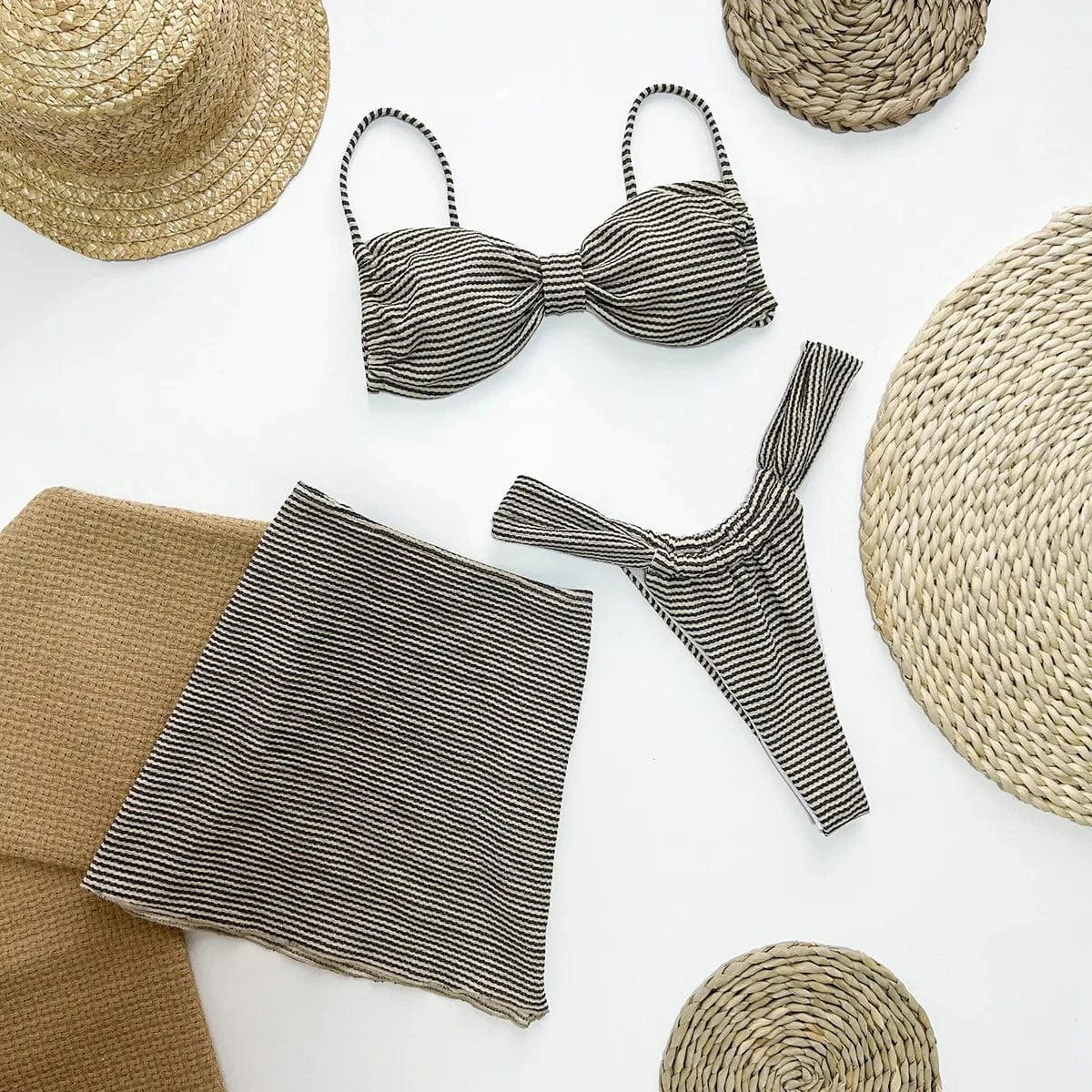 Maillot de bain femme en balconnet, rayé noir et blanc, avec culotte échancrée et pareo assorti.