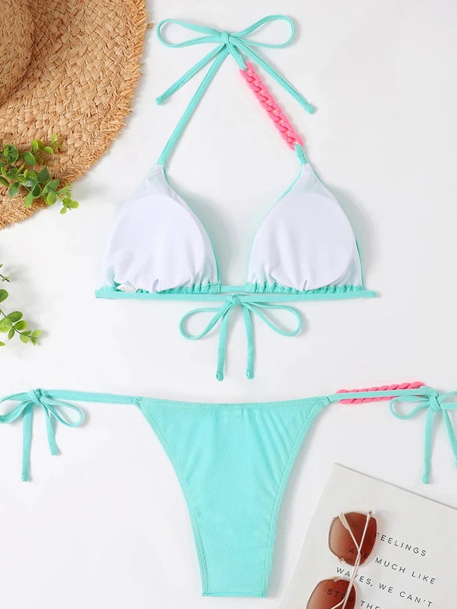 Maillot de bain femme bikini triangle turquoise avec détails rose, sur fond estival et plage.