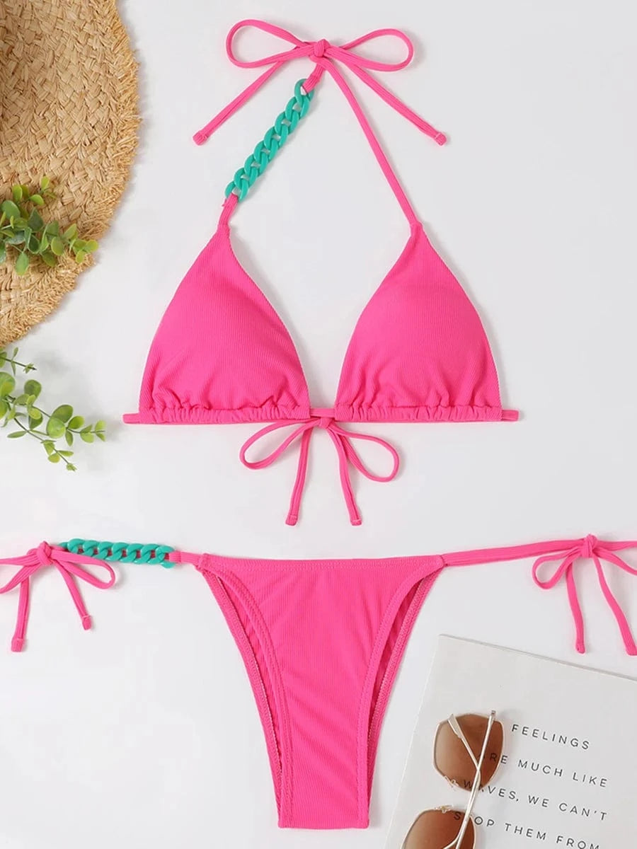 Maillot de bain femme triangle rose vif avec détails verts, style échancré moderne et tendance.