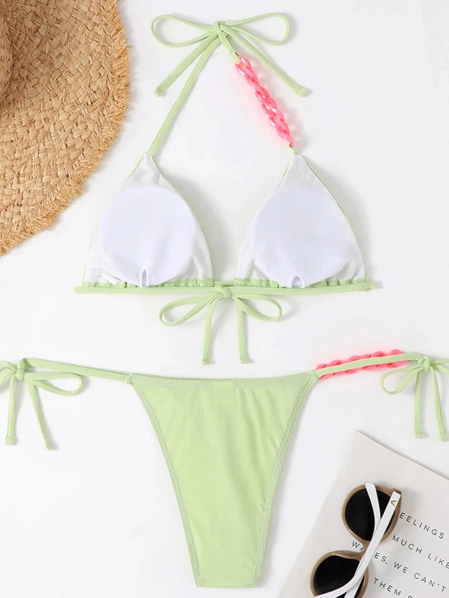 Maillot de bain bikini vert clair à nouer, design bandeau avec détails roses, style échancré élégant.