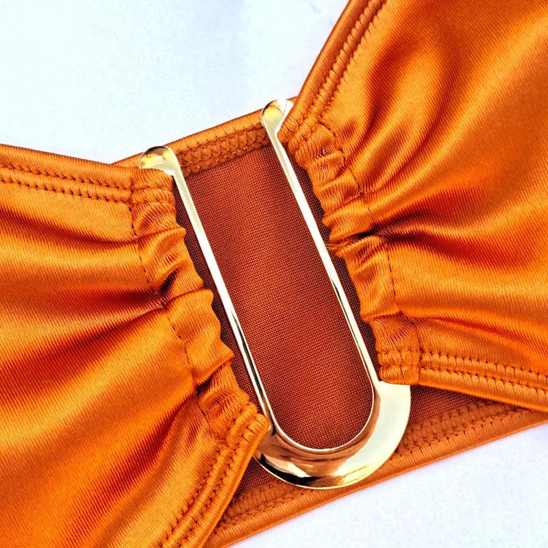 Maillot de bain bandeau orange élégant avec boucle dorée pour un style chic et sophistiqué.