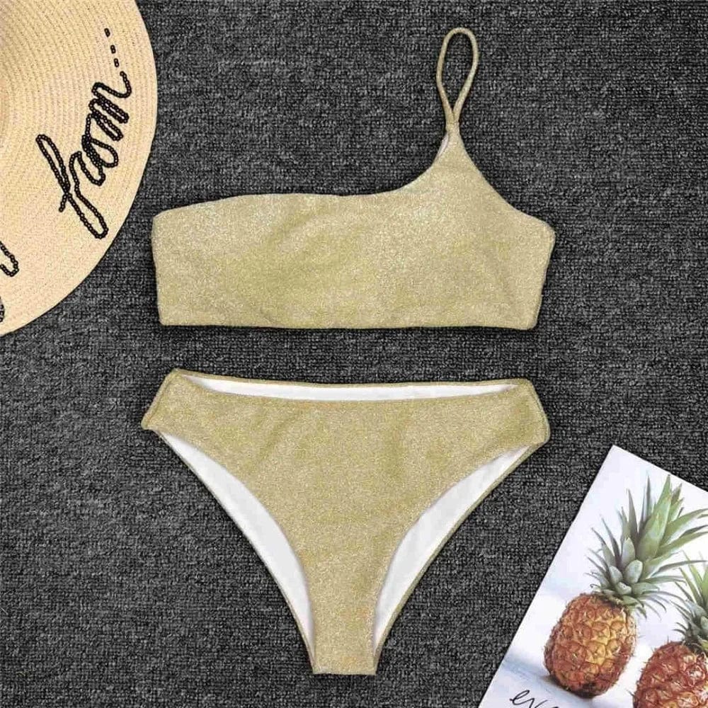 Maillot de bain femme asymétrique avec bandeau pailleté doré, idéal pour un style élégant.