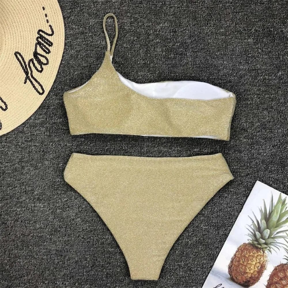 Maillot de bain bandeau pailleté doré à une épaule, style estival chic et moderne pour femme.