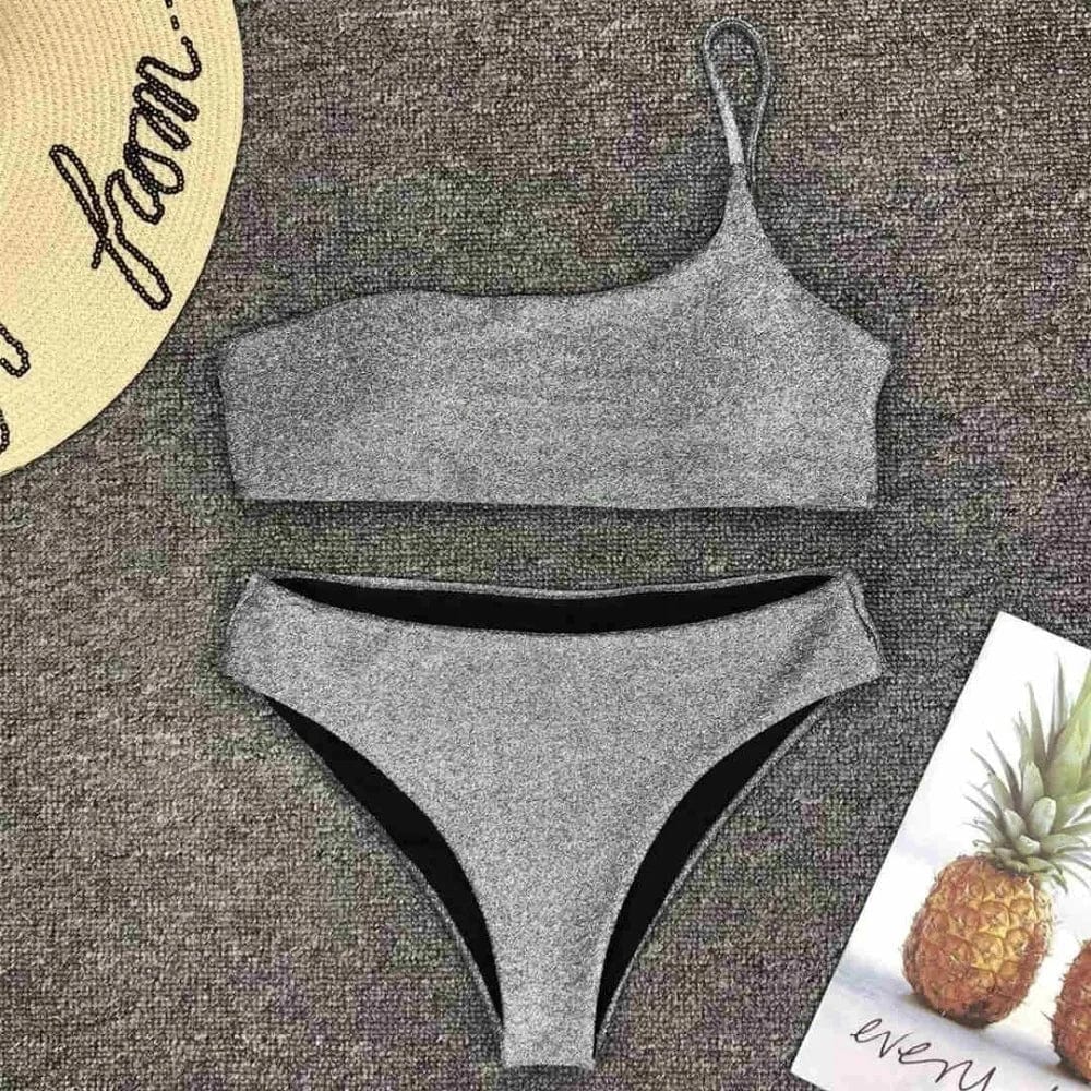 Maillot de bain femme, style bandeau asymétrique, couleur argentée pailletée pour l'été.