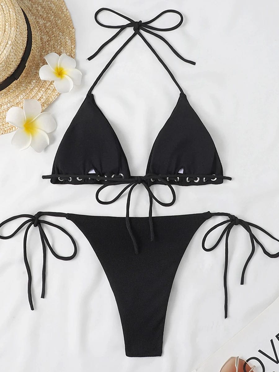 Maillot de bain bikini noir ficelle, idéal pour l'été avec chapeau de paille et fleurs tropicales.