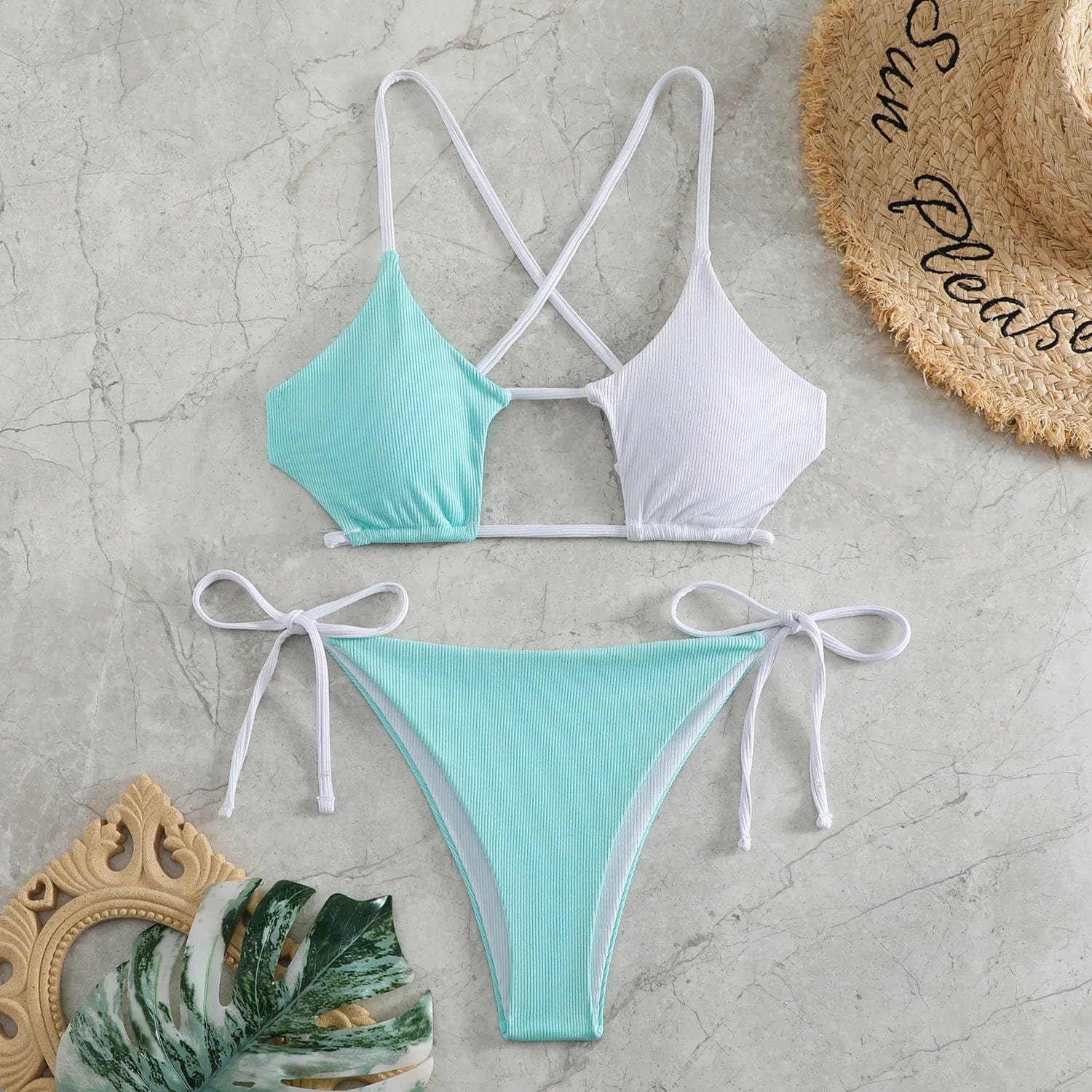 Maillot de bain bikini femme style patchwork vert et blanc avec cordons sur fond en marbre.