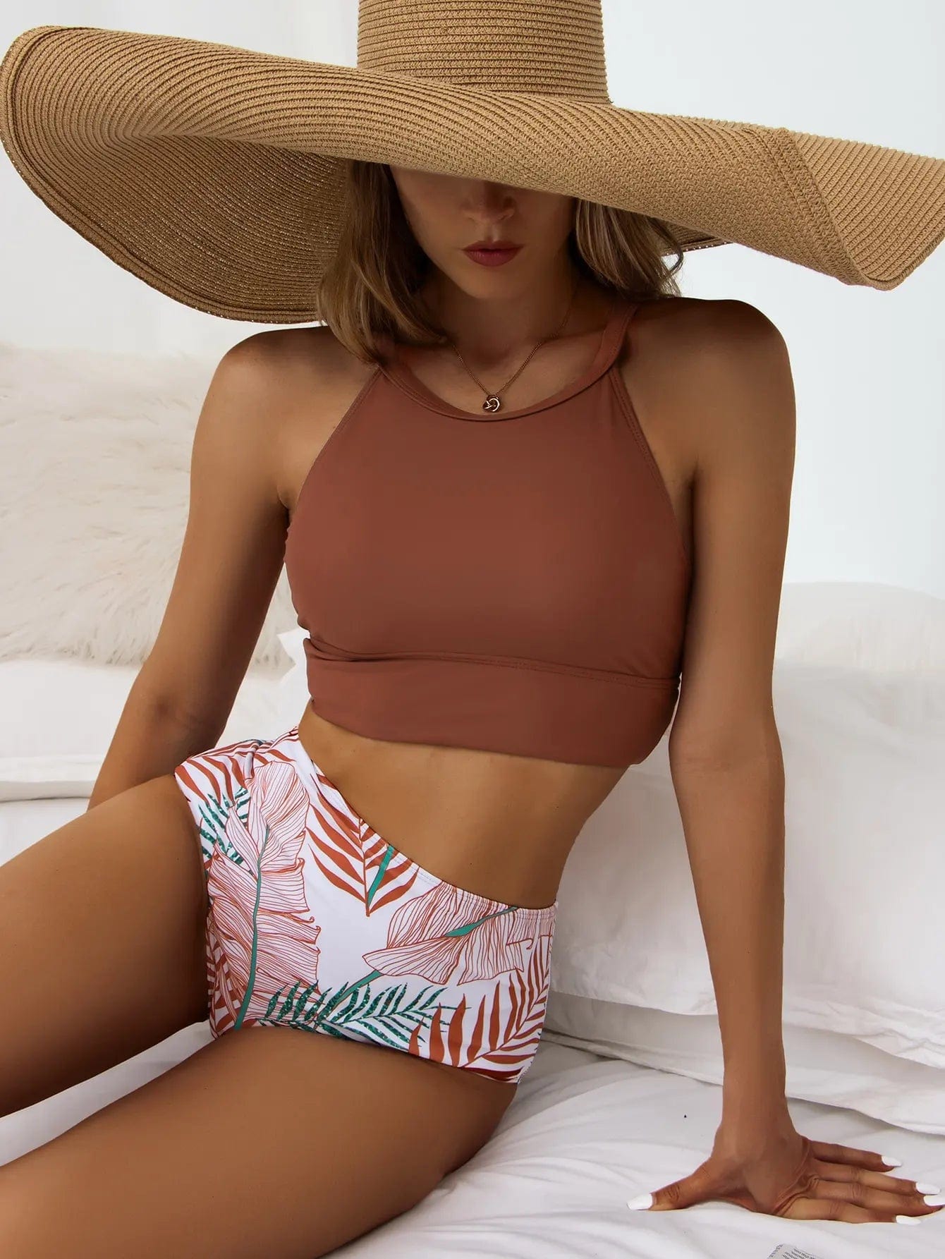 Maillot de bain femme bikini taille haute marron avec bas imprimé tropical et chapeau de paille.