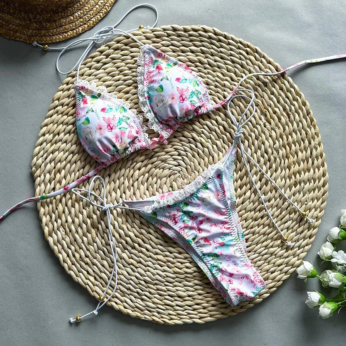 Maillot de bain deux pièces fleuri aux motifs colorés avec dentelles, style estival féminin.