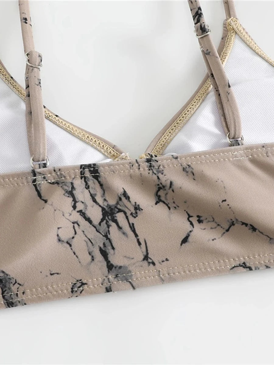Maillot de bain deux pièces pour femme avec imprimé marbre beige et bretelles fines ajustables.