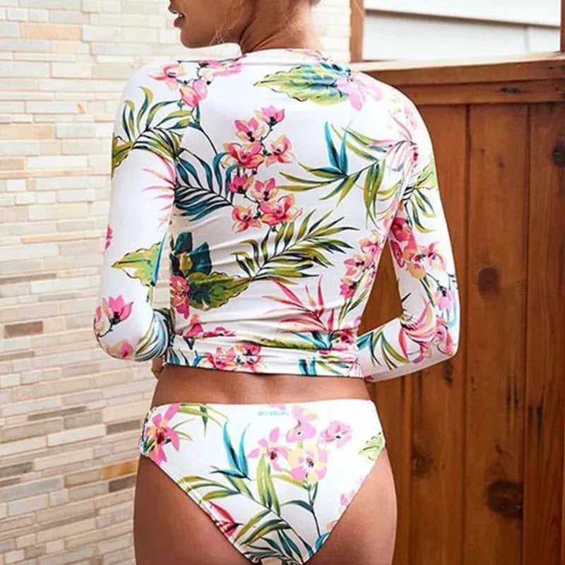 Maillot de bain fleuri pour femme, manches longues, motif tropical avec fleurs et feuilles colorées.