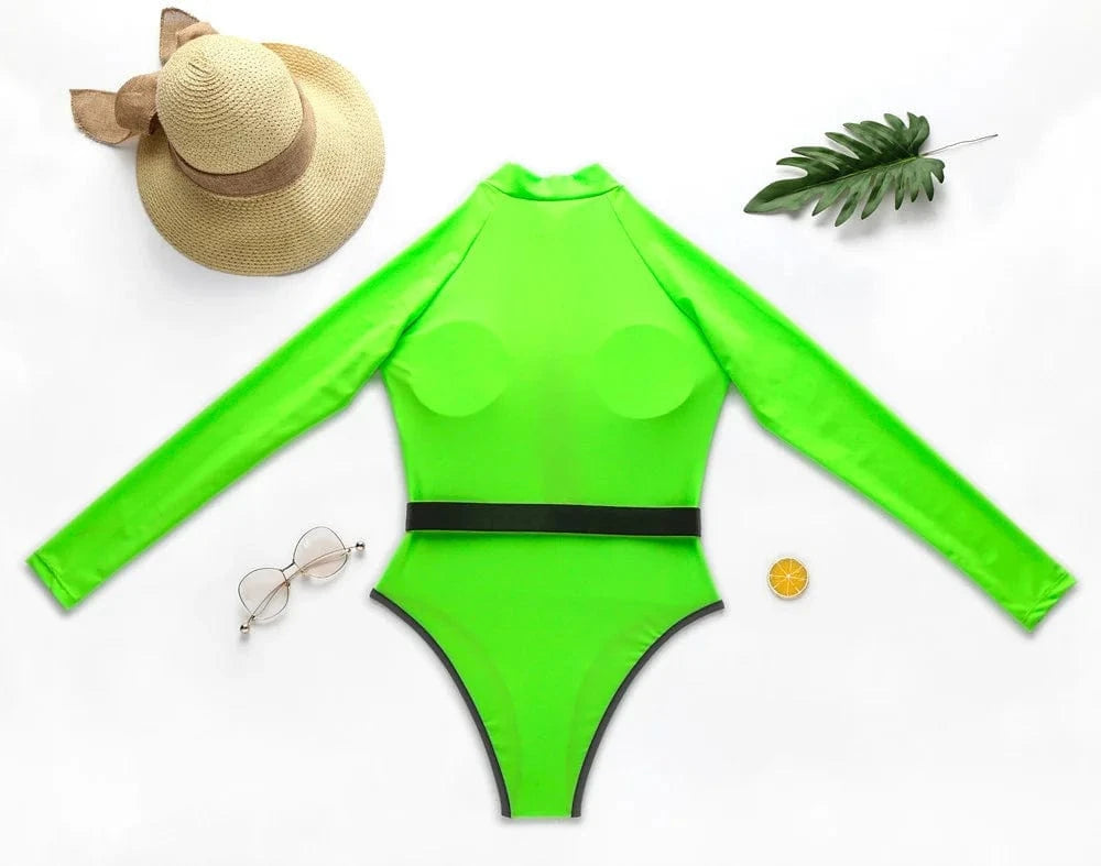 Maillot de bain une pièce vert fluo pour femme, manches longues, avec accessoires de plage.