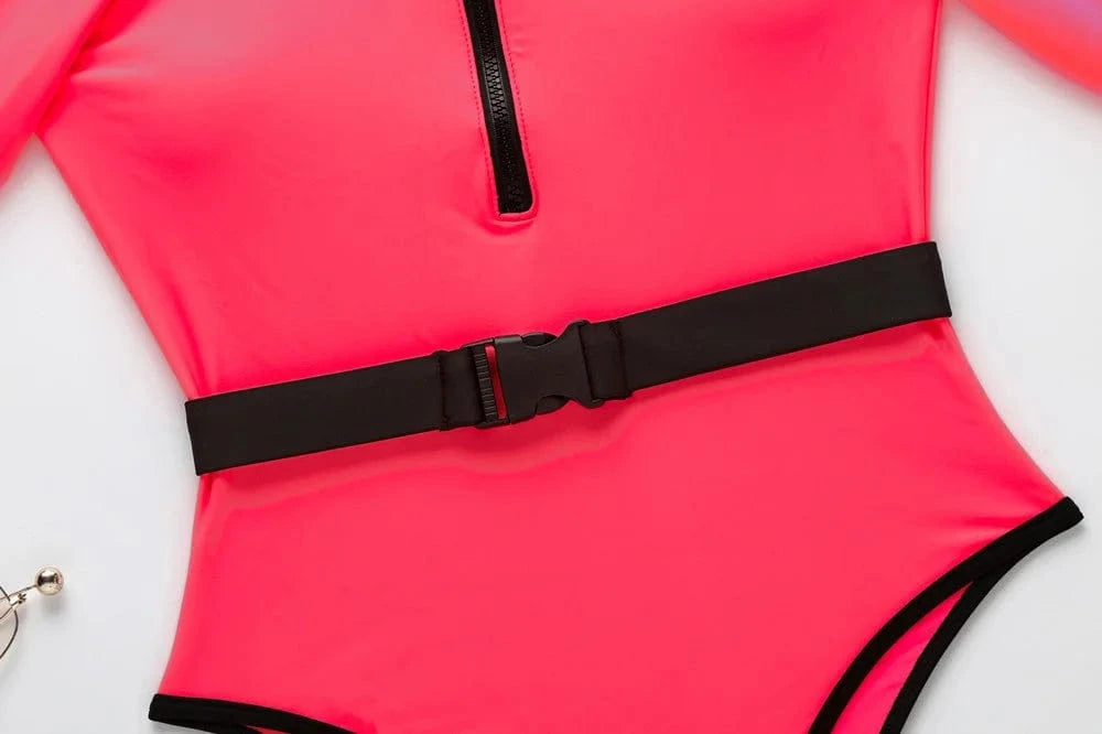 Maillot de bain femme à manches longues fluo avec ceinture noire et fermeture éclair frontale.