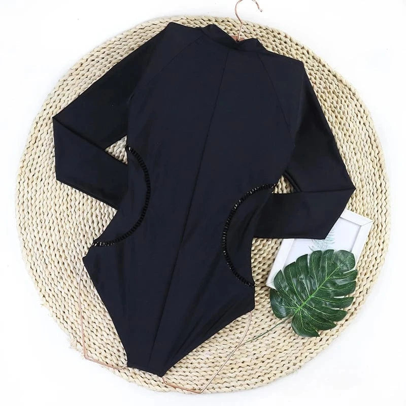Maillot de bain noir manches longues femme, élégant et moderne pour un style chic à la plage.