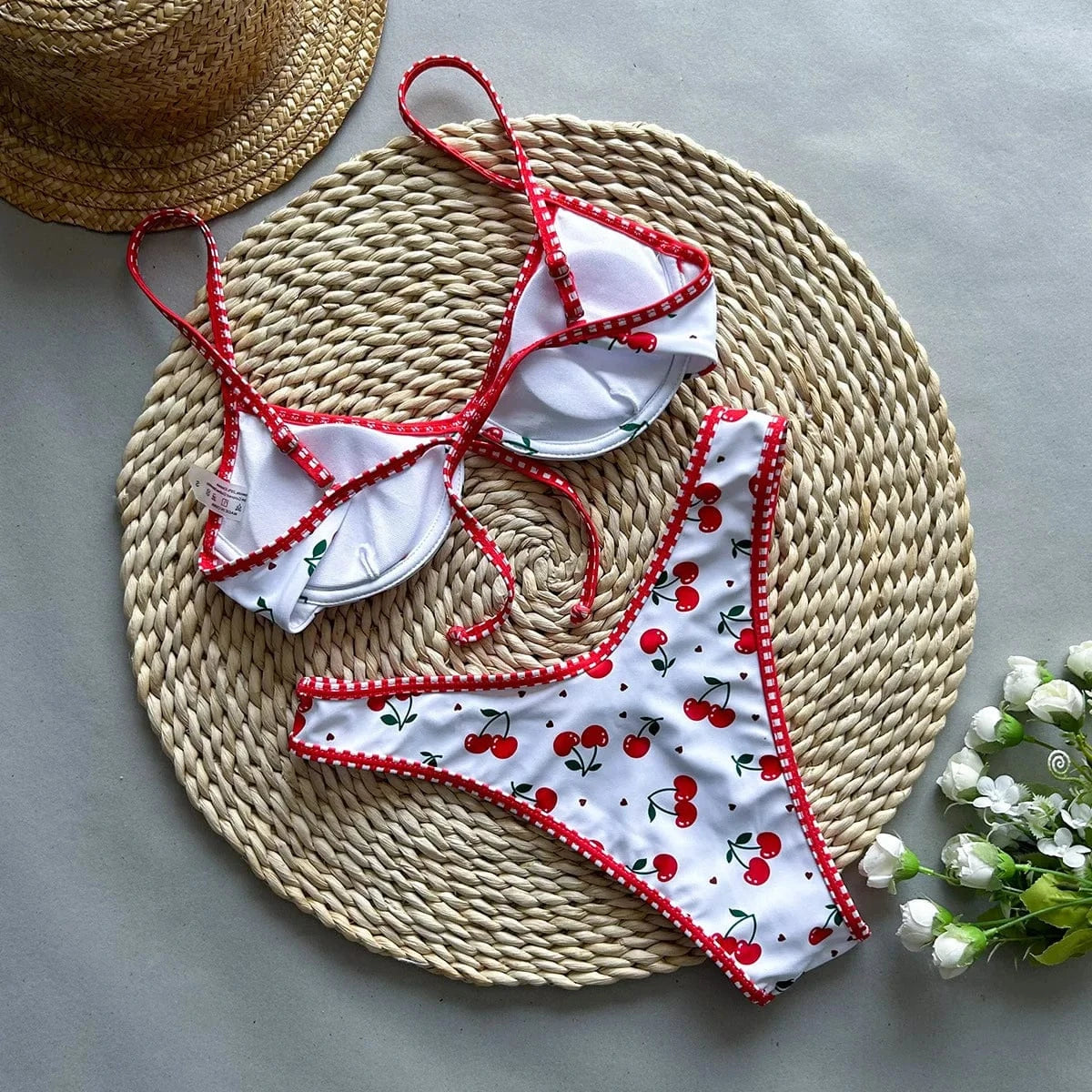 Maillot de bain bikini femme, imprimé cerises, à bordures rouges, style estival et tendance.