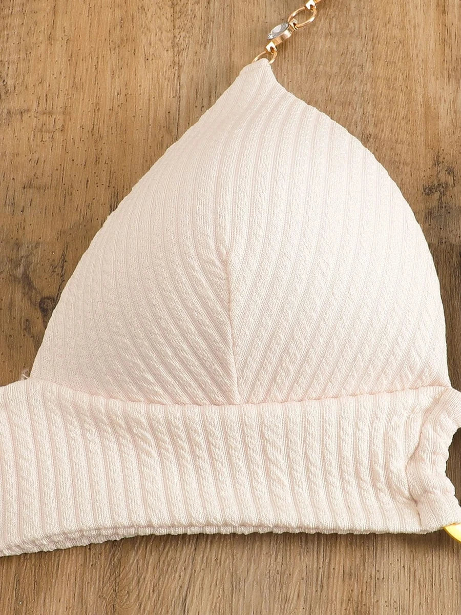 Maillot de bain femme triangle beige texturé, élégant pour l'été sur plage ensoleillée.