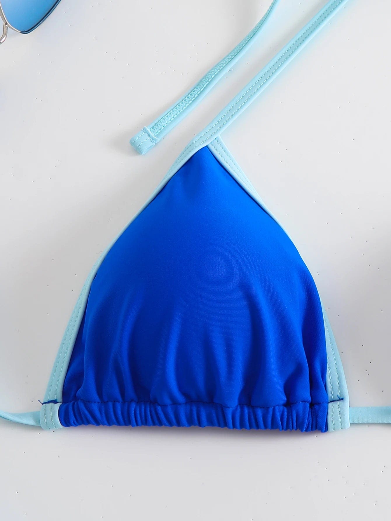 Maillot de bain triangle pour femme, bleu vif avec ficelles ajustables pour un style estival chic.