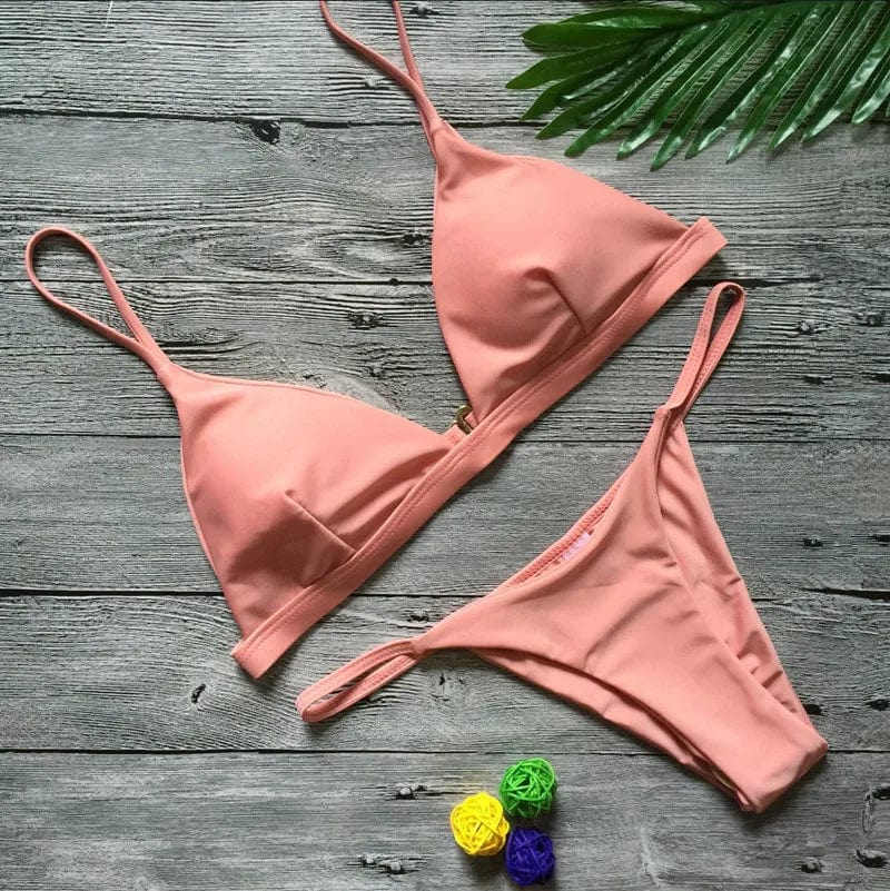 Maillot de bain femme triangle échancré terracotta sur fond bois avec décoration végétale.