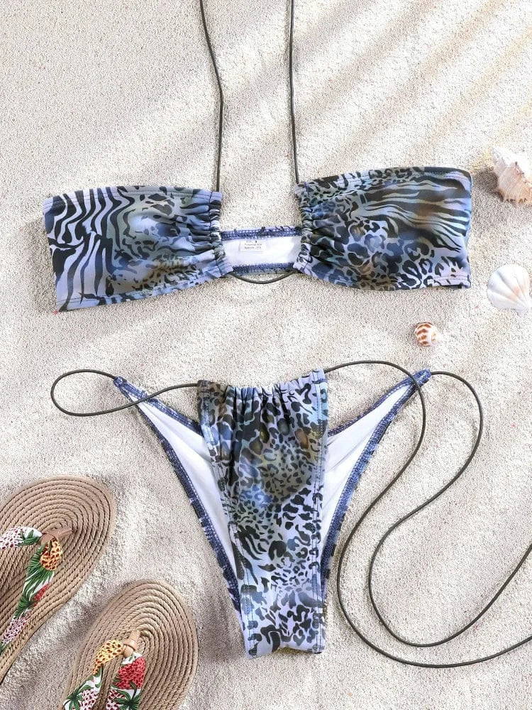 Maillot de bain femme triangle ficelle imprimé animal sur plage avec coquillages et sandales.