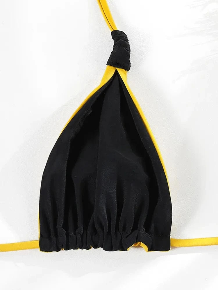 Maillot de bain femme triangle noir et jaune élégant avec fines bretelles ajustables.