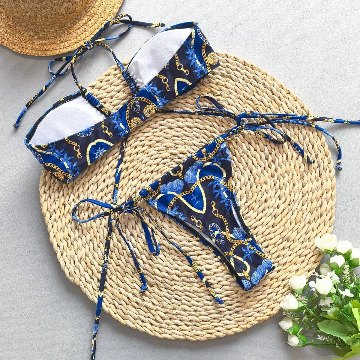 Maillot de bain femme style bandeau, motifs bleus et dorés sur fond noir, élégant et moderne.
