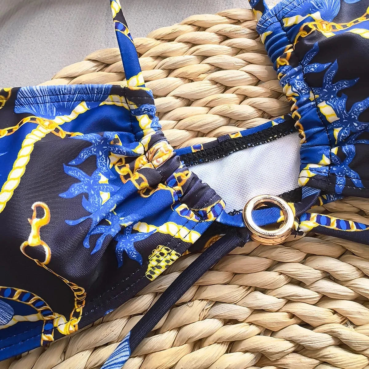 Maillot de bain femme triangle imprimé marin bleu avec détails dorés et boucles élégantes.