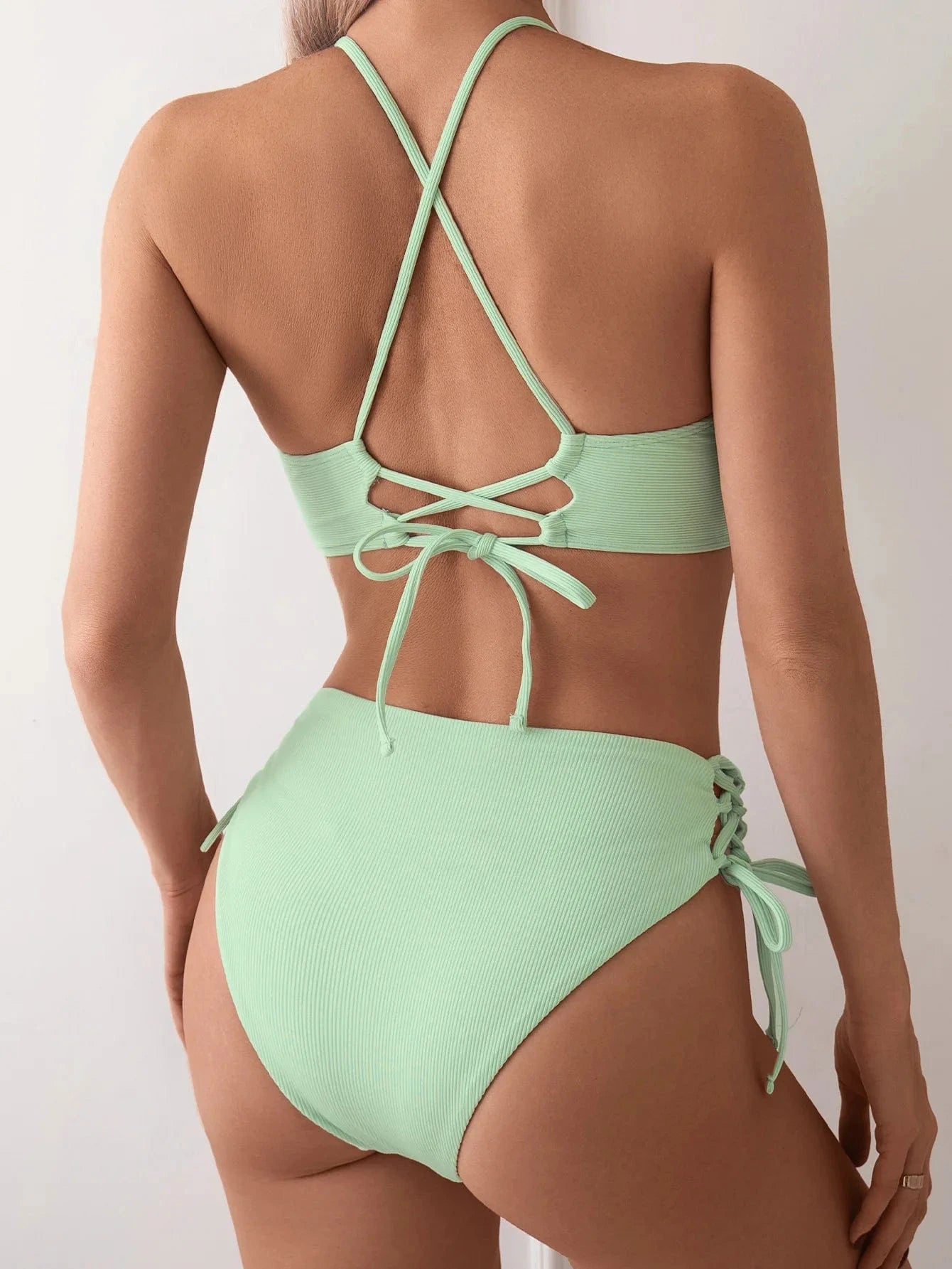 Maillot de bain vert menthe femme avec dos croisé et détails échancrés, style moderne et élégant.