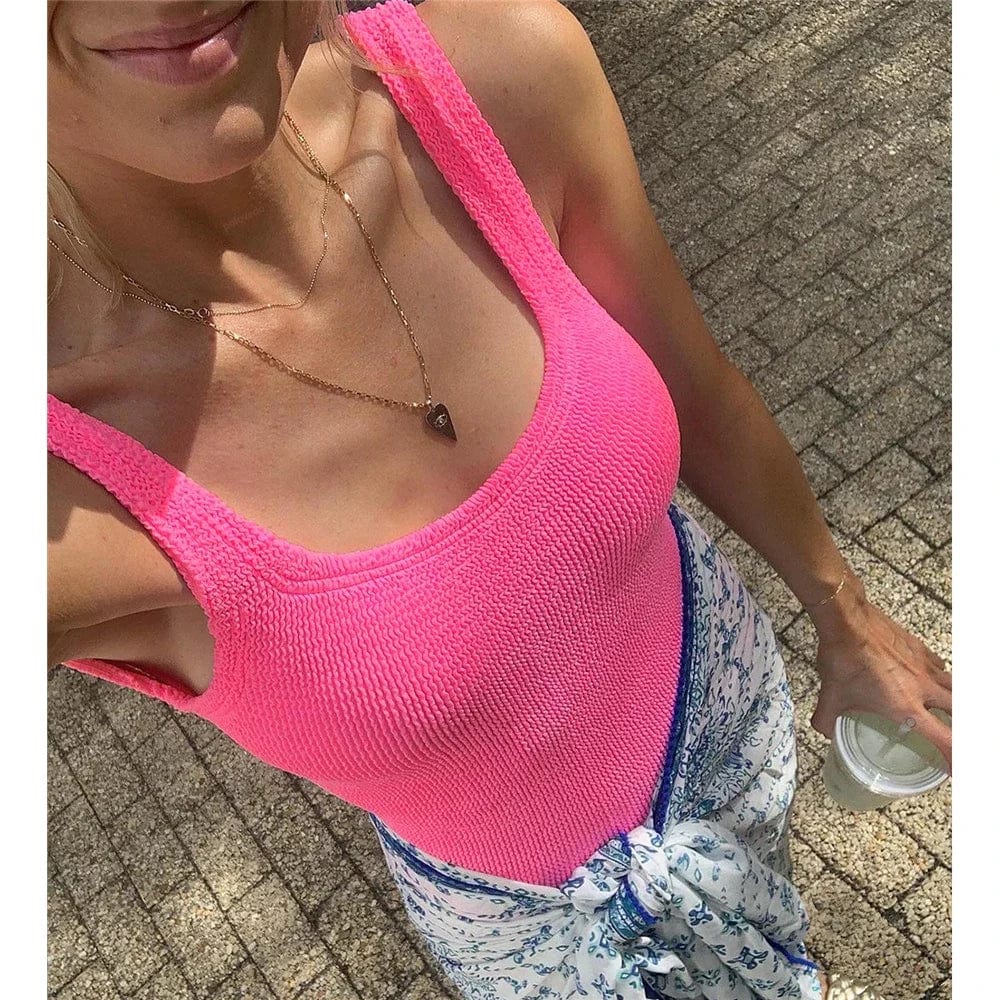 Maillot de bain une pièce rose vif pour femme, style estival avec paréo imprimé élégant.