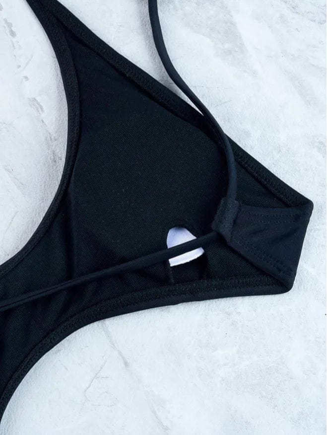 Maillot de bain une pièce noir élégant pour femme, style moderne et détails sensuels raffinés.