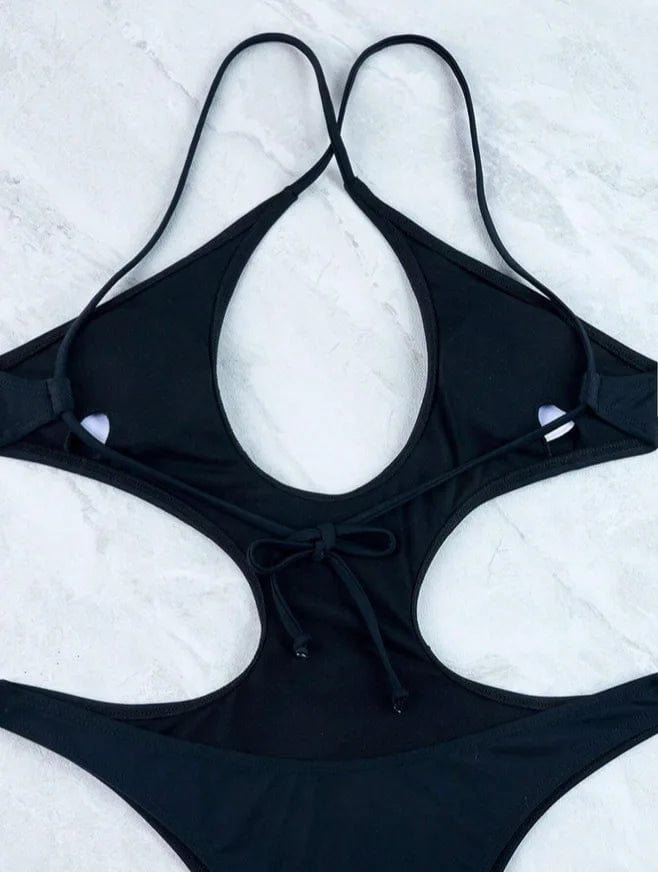 Maillot de bain une pièce femme noir, design sexy avec découpes élégantes et bretelles fines.