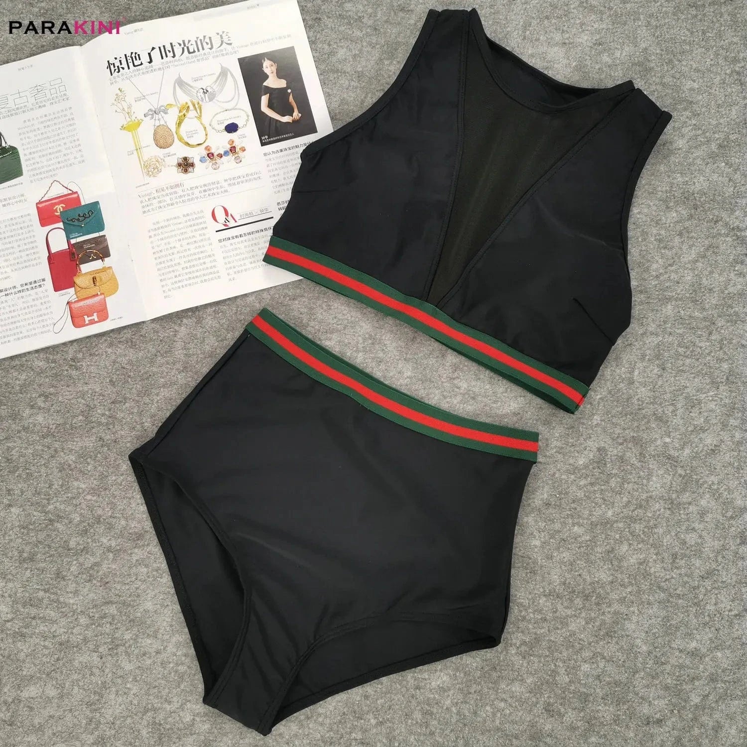 Maillot de bain noir femme taille haute avec détails à rayures vertes et rouges, style sport.